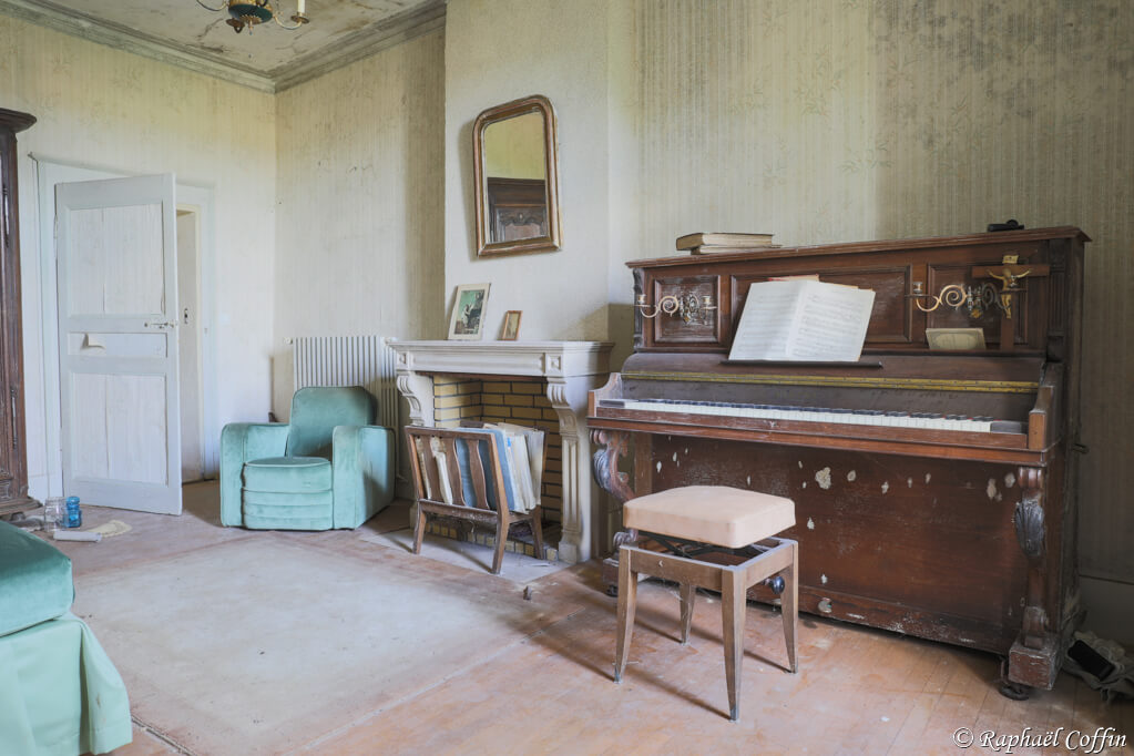 Salon avec piano et canapé